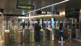 Usuarios en la estación de metro de Diagonal pasan sus tarjetas para poder acceder a las vías / JORDI SUBIRANA