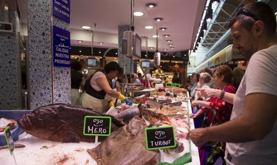 Distintos clientes compran en una parada de pescado de Sant Antoni / HUGO FERNÁNDEZ