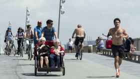 Dos ancianas recorren en bici-taxi la playa de Barcelona / HUGO FERNÁNDEZ
