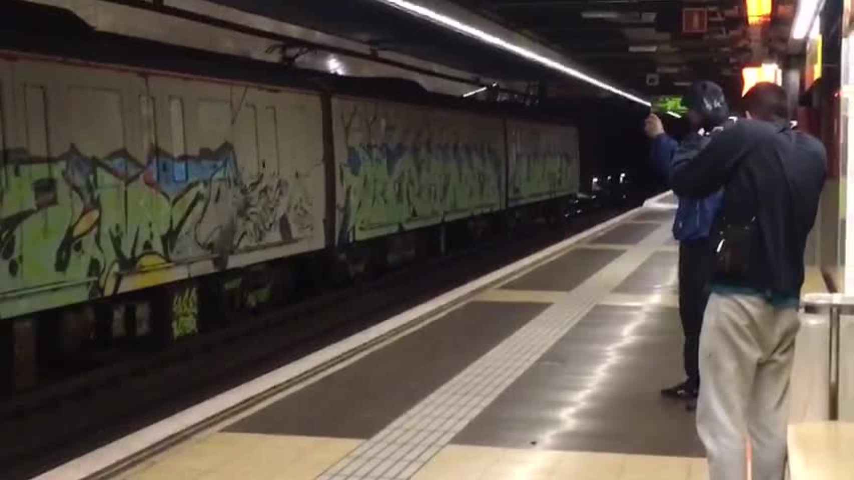Dos de los grafiteros graban el convoy con sus pintadas, con el metro parado, en la estación de Selva de Mar / MÒNICA TUDELA EL PERIÓDICO DE CATALUNYA