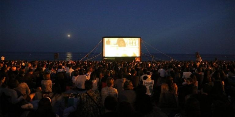 Espectadores durante la proyección de un largometraje del Cinema Lliure en una playa de Barcelona / ARCHIVO