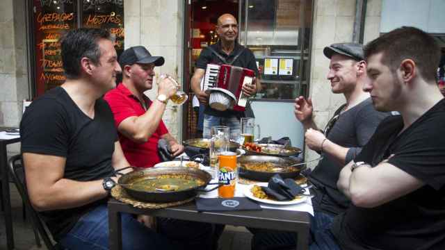 Turistas disfrutando de su paella en la Boqueria | HUGO FERNÁNDEZ