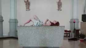 Una turista se tumba en un altar de una iglesia de la Barceloneta / LA VANGUARDIA