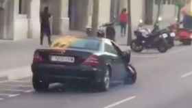 El coche fugado, a tres ruedas, en la calle de Aragó / @ALEXXBRN