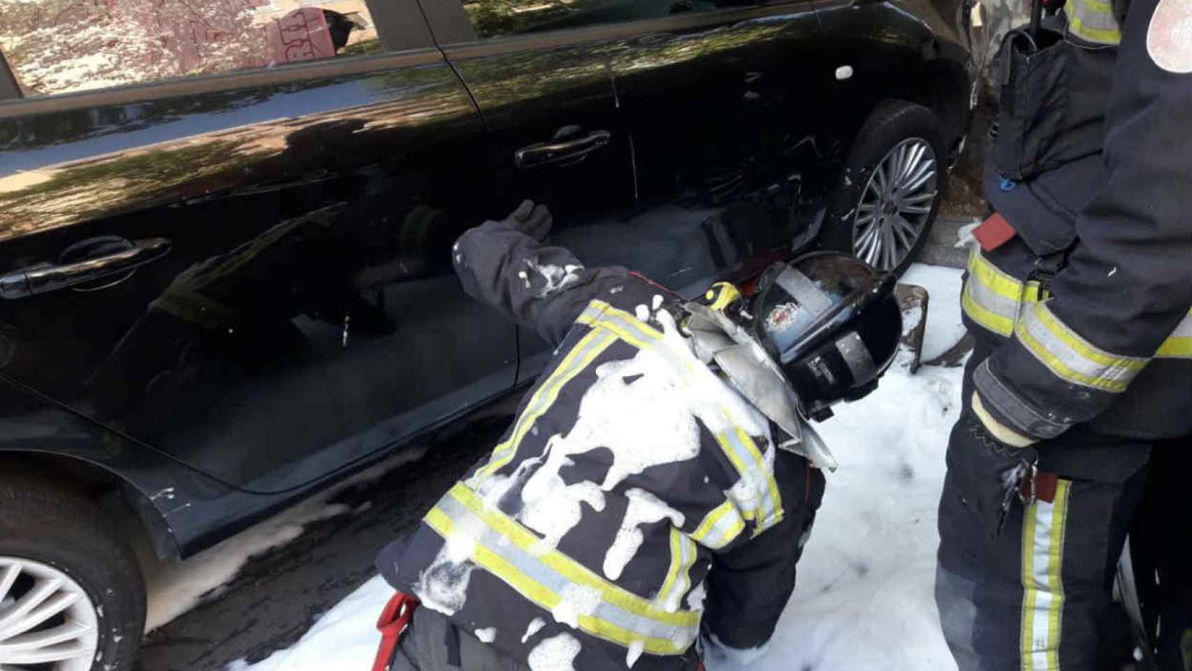 Los bomberos inspeccionan los bajos del vehículo afectado / @BCN_Bombers