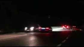 Un coche haciendo una carrera de noche está a punto de chocar de frente con otro vehículo