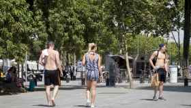 Turistas sin camiseta paseando por la Barceloneta, por el fuerte calor de Barcelona / HUGO FERNÁNDEZ
