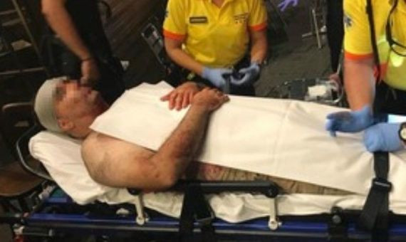 El turista agredido, tumbado en una camilla, atendido por el servicios médicos. 