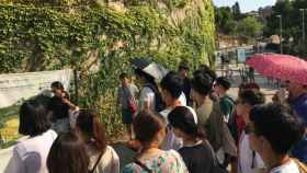 Una guía instruye a un grupo de turistas japoneses en el Park Güell / MIKI