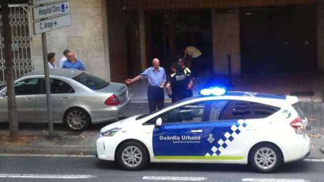 Una patrulla de la Guardia Urbana procede a multar al conductor de un coche / MIKI