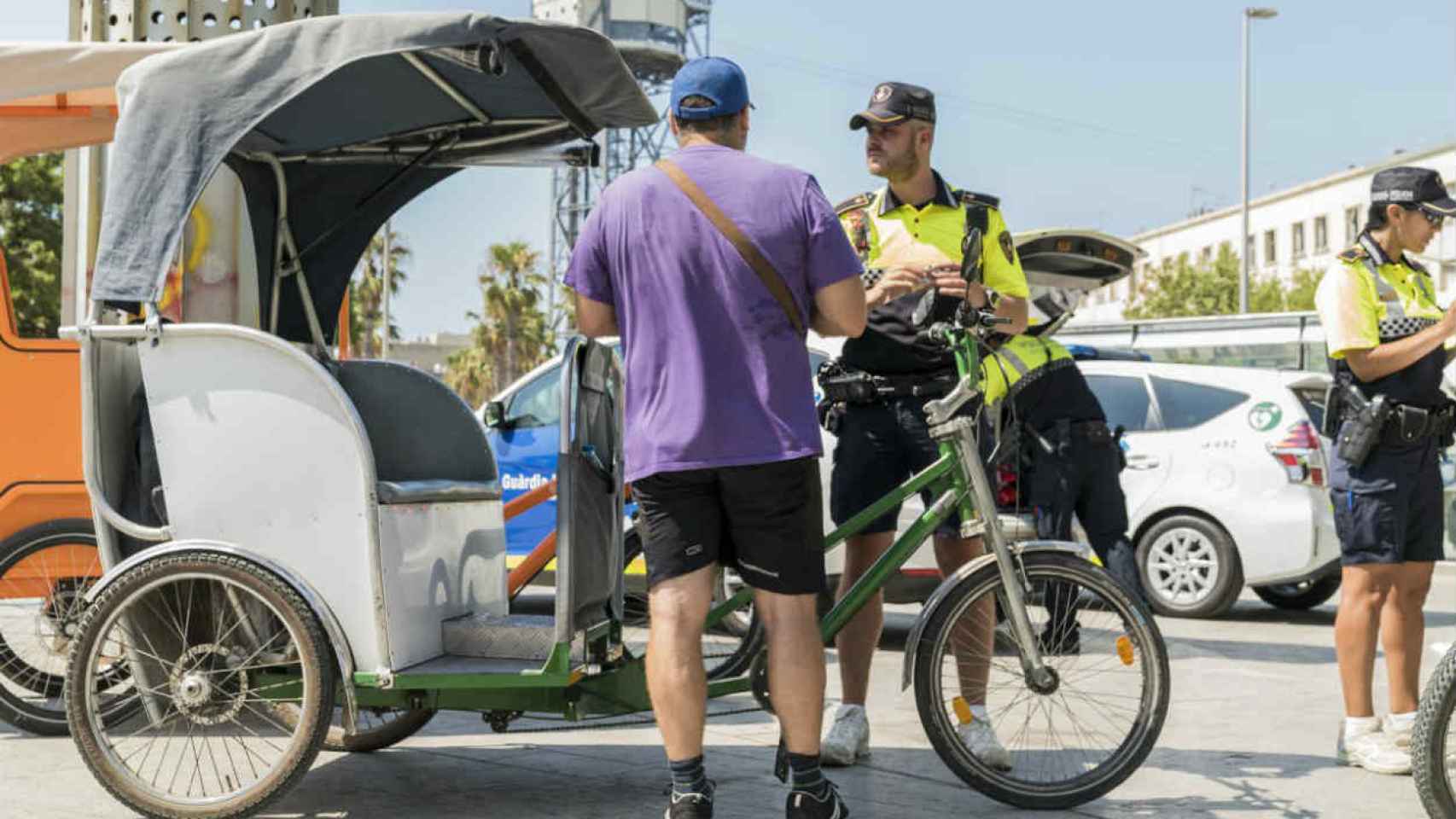 Unos guardias urbanos multan al conductor de un bicitaxi / Ajuntamente Barcelona