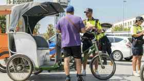 Unos guardias urbanos multan al conductor de un bicitaxi / Ajuntamente Barcelona