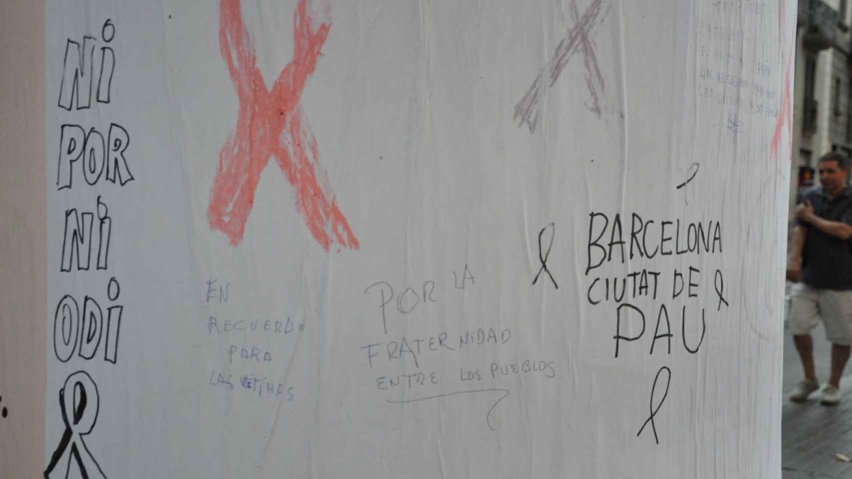 Varios grafitis escritos por manos anónimas en un pirulo publicitario de las Ramblas / MIKI