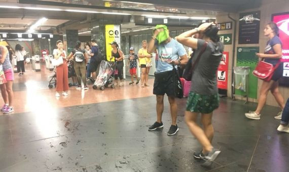 Algunos viajeros secándose en el Metro tras la lluvia | AROA ORTEGA