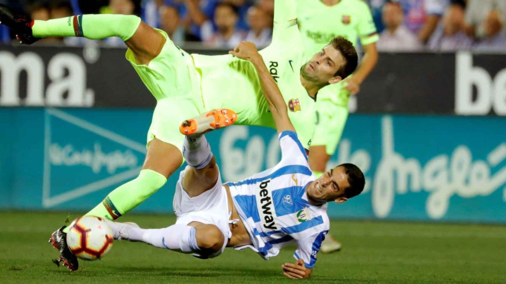 Gerard Piqué, defensa del Barça, pugna con un futbolista del Leganés, en Butarque / EFE