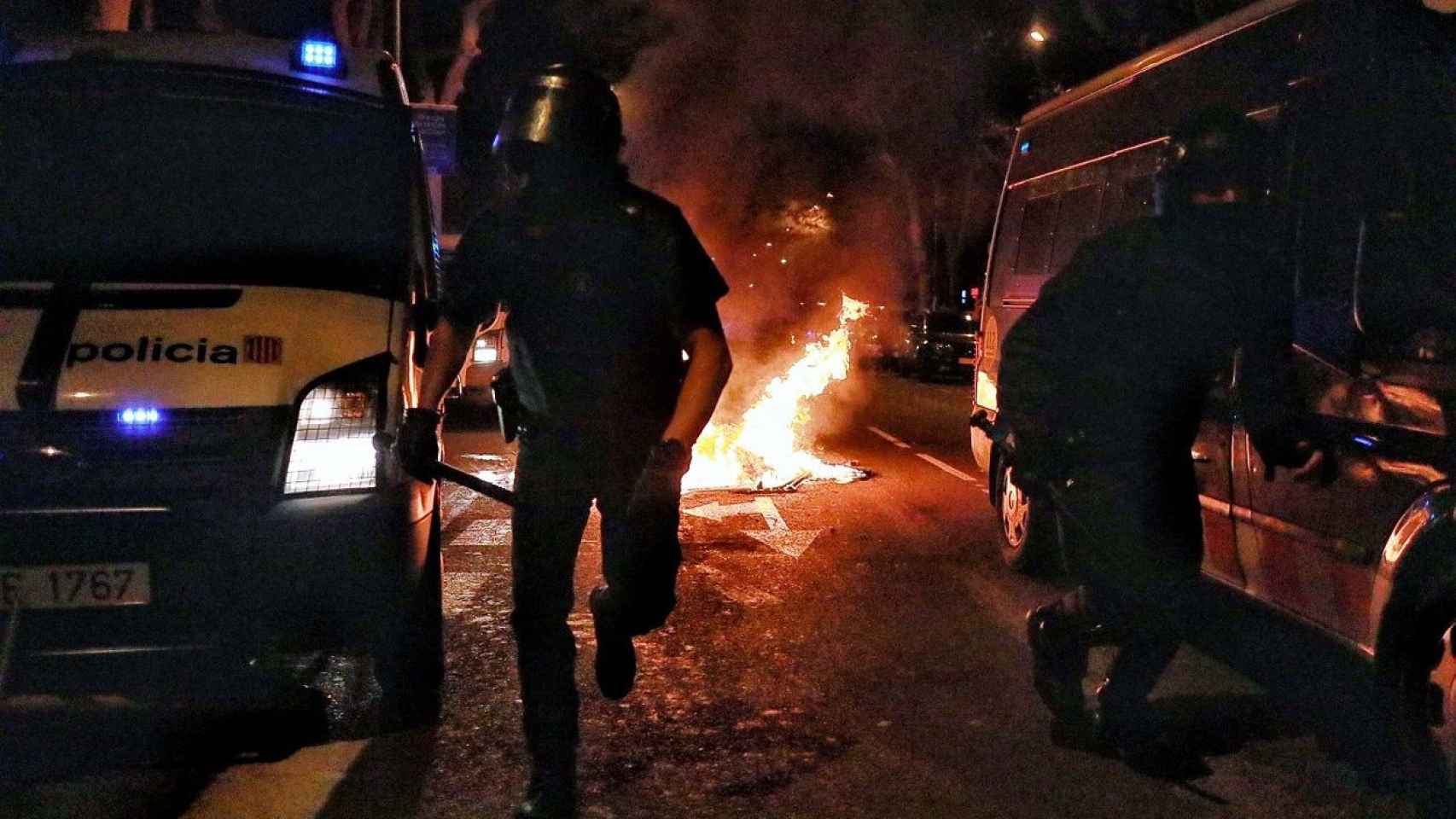 Dos policÍas parecen salir del infierno persiguiendo a los incendiarios / HUGO FERNÁNDEZ