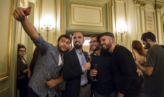 Un grupo de amigos en el Saló dels Miralls del Liceu sacándose un selfie | HUGO FERNÁNDEZ