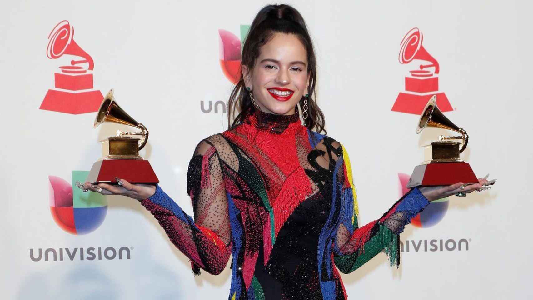 Rosalía sujetando los dos premios Grammys