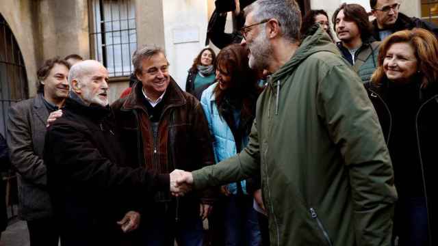 El fraile Joan Botam (izq.) saluda al diputado de la CUP Carles Riera, entre diputados soberanistas del Parlament / EFE, Toni Albir