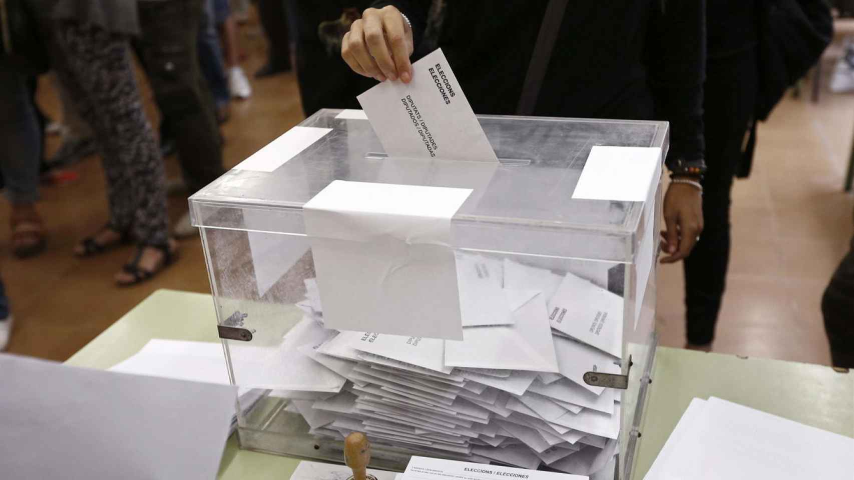 Un votante coloca un sobre en una urna durante las elecciones en Barcelona / EFE