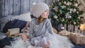 Una niña rodeada de regalos de Navidad / PIXABAY