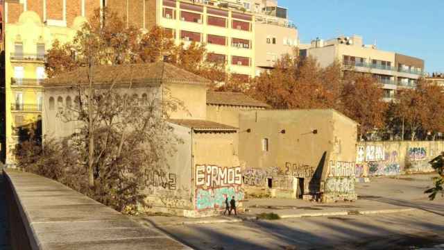 La Torre del Fang, en la Sagrera, con uno de los 'okupas' caminando junto al edificio / JORDI SUBIRANA