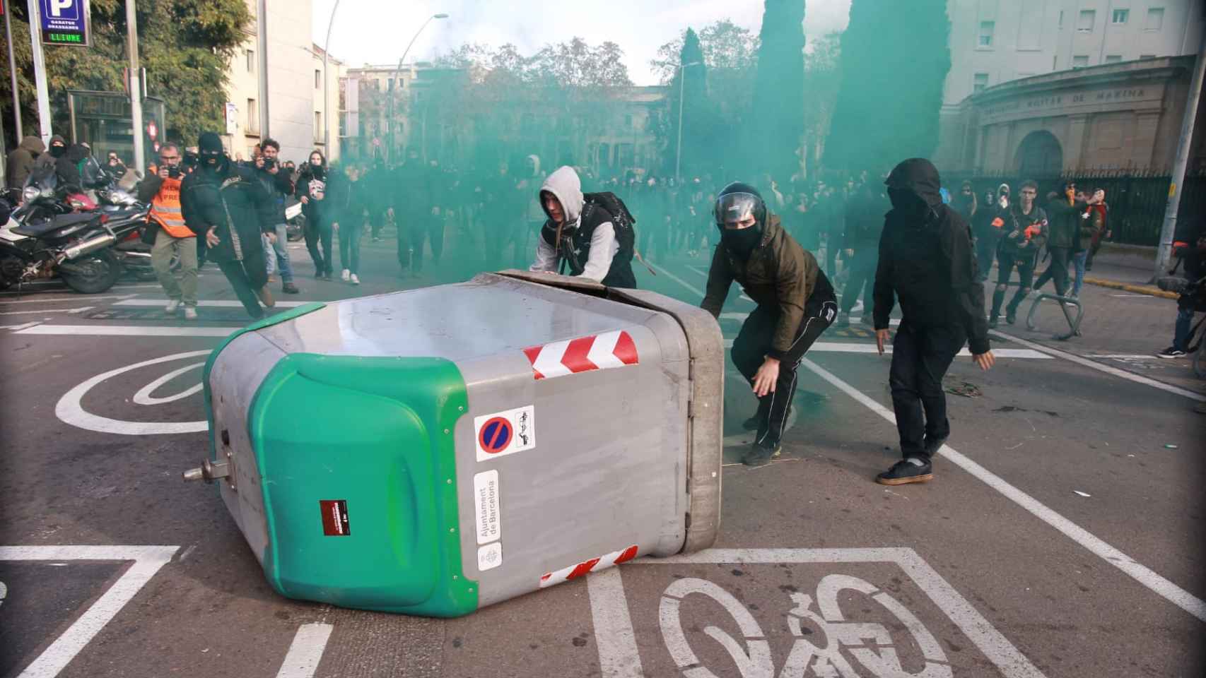 Radicales empujan contenedores para formar barricadas / HUGO FERNÁNDEZ