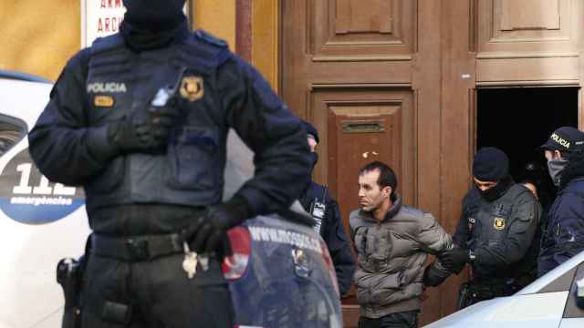 Los Mossos d'Esquadra trasladan a uno de los detenidos en el Clot, en la operación antiterrorista / EFE/ALEJANDRO GARCÍA