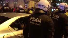 Agentes de la Guàrdia Urbana protegen a un vehículo VTC de los taxistas en Via Laietana.