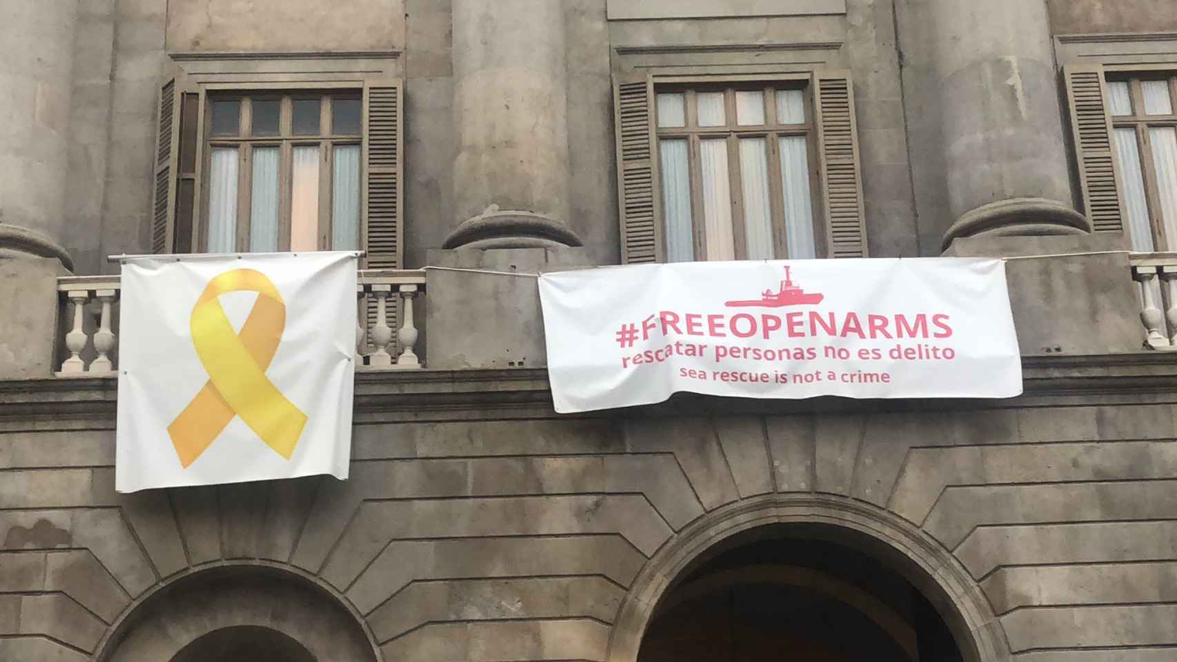 Imagen de las pancartas que cuelgan de la fachada del Ayuntamiento de Barcelona / TWITTER