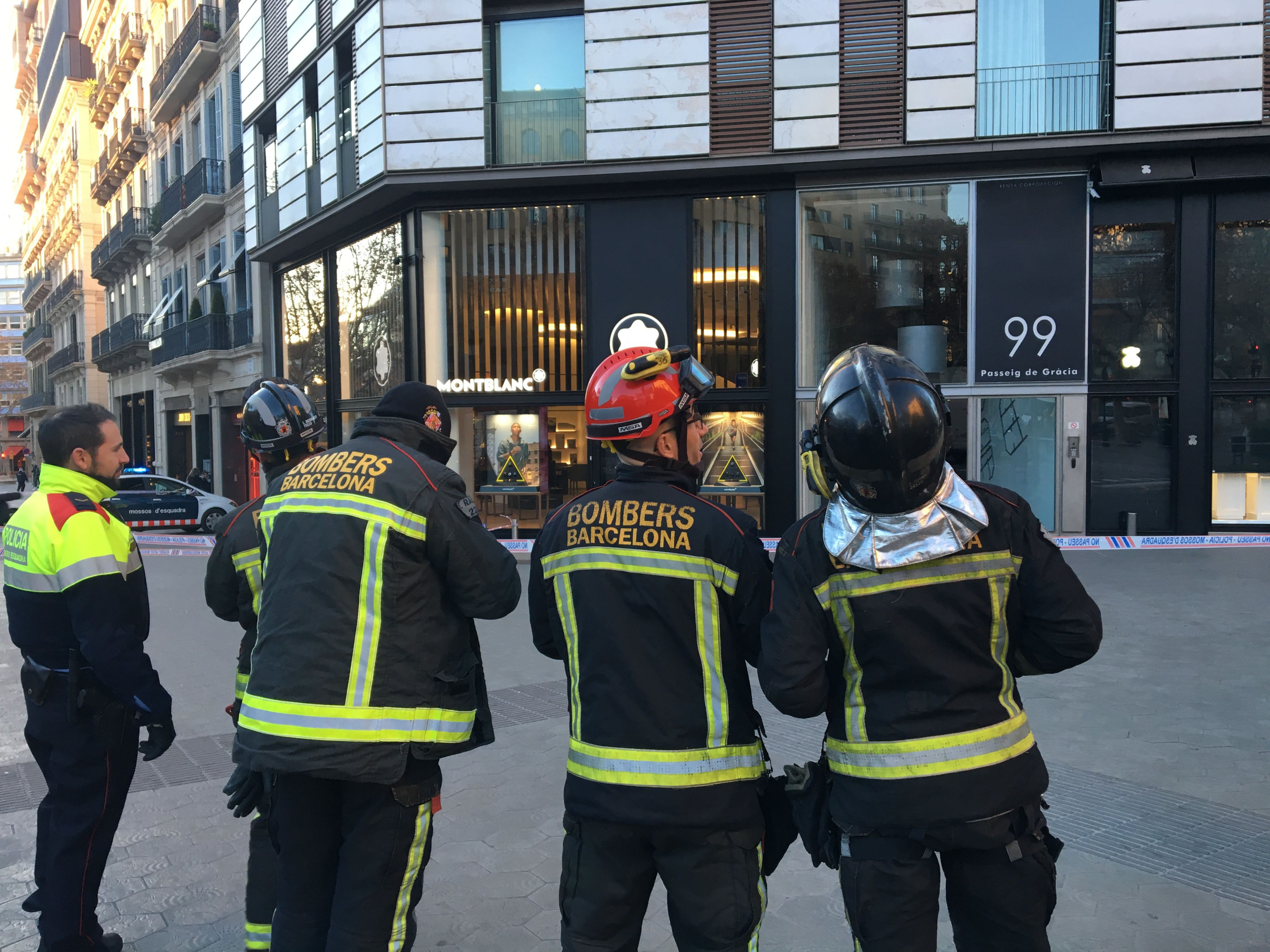 Bomberos de Barcelona observan la fachada del edificio que ha sufrido un desprendimiento en paseo de Gràcia / PABLO ALEGRE