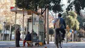 Una bicicleta pasa junto a una parada de bus en una calle de Barcelona / HUGO FERNÁNDEZ