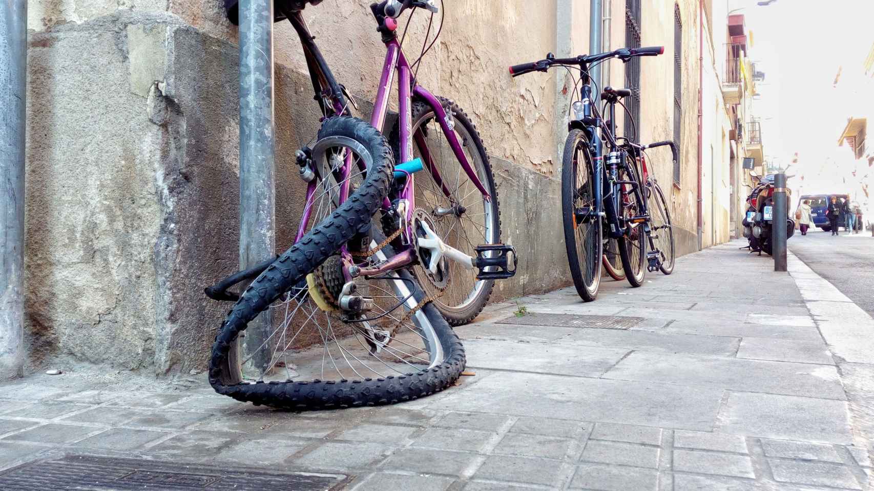 Bibicleta aparcada en la calle con la rueda deformada / HUGO FERNÁNDEZ