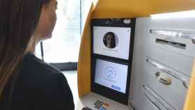 Una cliente de CaixaBank en un cajero automático equipado con el sistema de reconocimiento facial