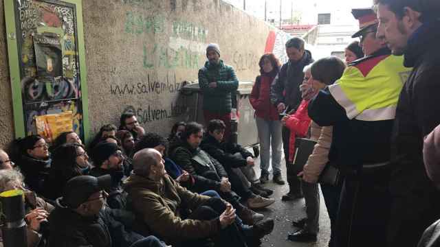 Las personas desalojadas de las casas de calle Encarnació junto a los Mossos / MA