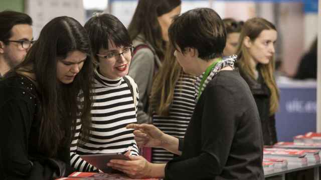 Una asesora atienda a dos estudiantes en el Salón del Futura