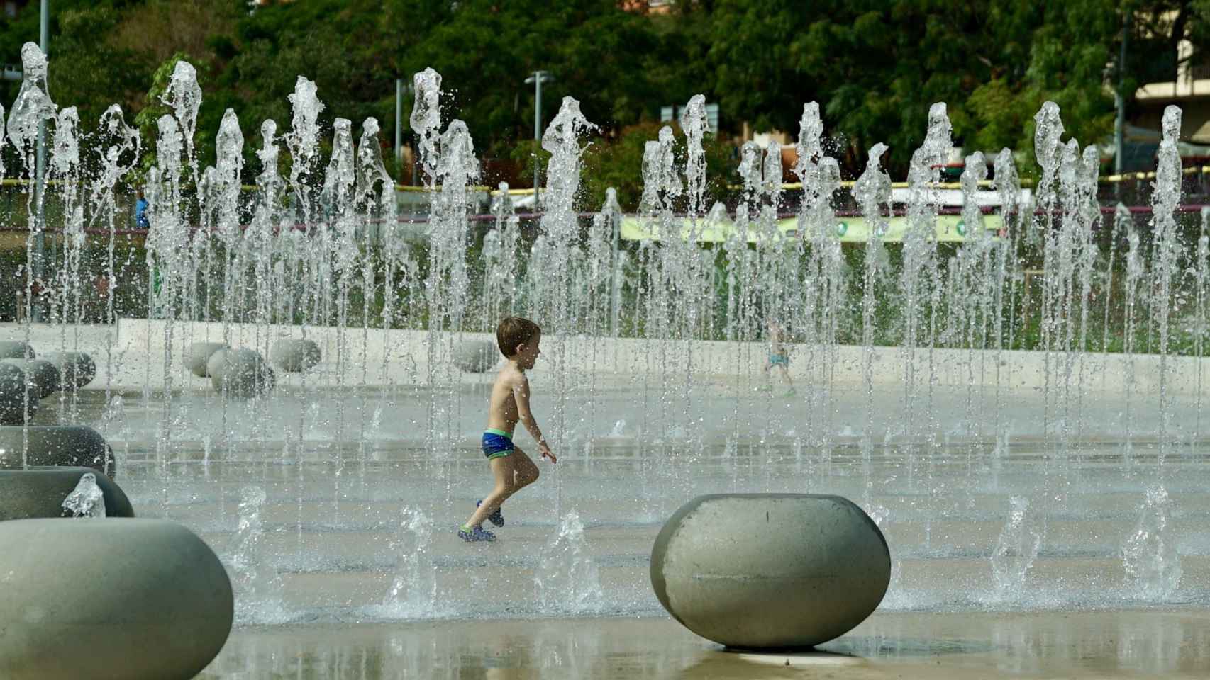 La fuente del parque de Antoni Santiburcio, el pasado verano, con un niño banándose / AYUNTAMIENTO DE BARCELONA