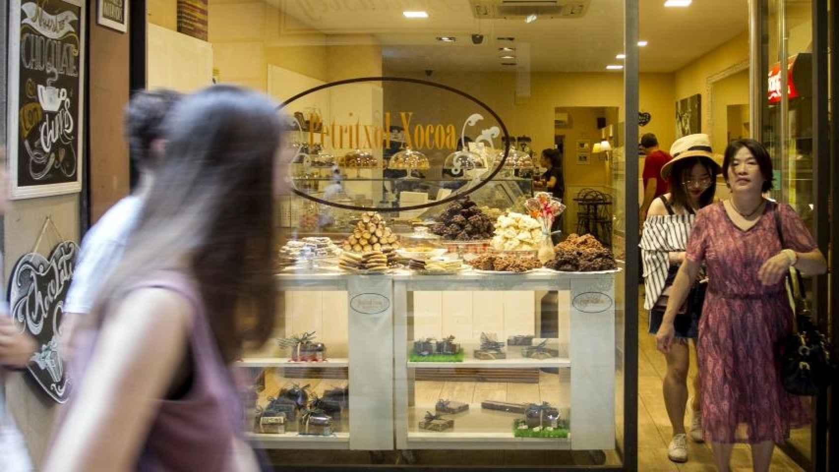 Turistas paseando por delante de una chocolatería de la calle Petritxol, en Barcelona