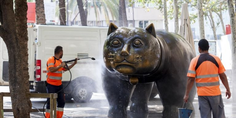 Personal de limpieza usando una manguera para limpiar el gato de Botero de la Rambla Raval / HUGO FERNÁNDEZ