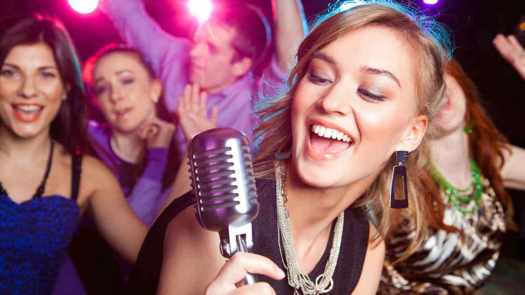 Un grupo de amigos cantando en un karaoke / SHUTTERSTOCK