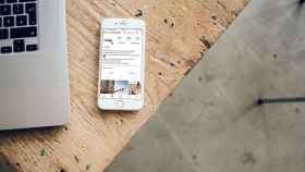 Un teléfono móvil, instrumento habitual de los 'Influencers', con la portada de Instagram y su algoritmo encima de un escritorio de madera / UNSPLASH