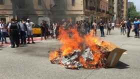 Mochilas, neumáticos y cajas ardiendo ante la sede de Glovo en Barcelona / EP