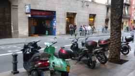 Motos aparcadas en la acera, justo delante del párking subterráneo exclusivo de calle de Gran de Gràcia / JORDI SUBIRANA