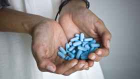 Una persona sujetando un buen puñado de pastillas de Viagra