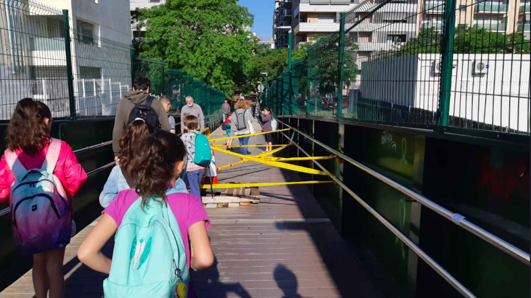 Niños pasando por el puente de la Maquinista, que tiene dos agujeros enormes sin arreglar / TWITTER