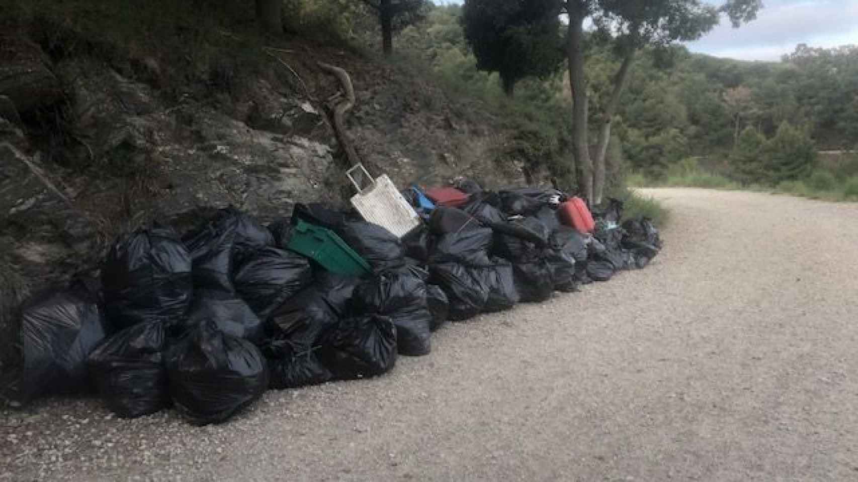 Bolsas de basura, objetos abandonados y maletas de viaje podridas y amontonadas en la carretera de les aigües de Barcelona