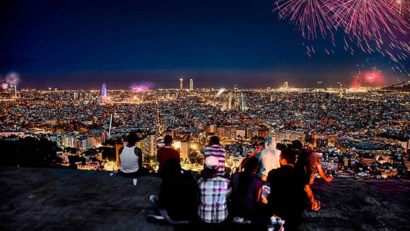 Vista panorámica de Barcelona con calles iluminadas y fuegos artificiales