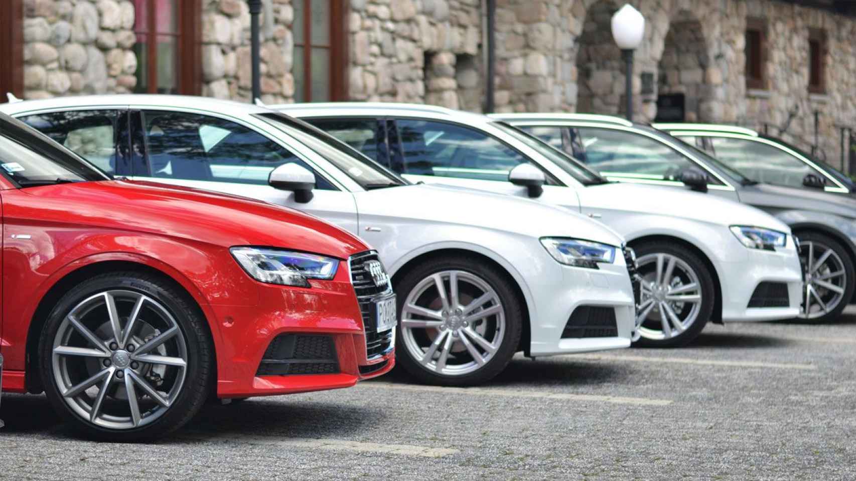 Conjunto de vehículos de la marca Audi aparcados en batería en la vía