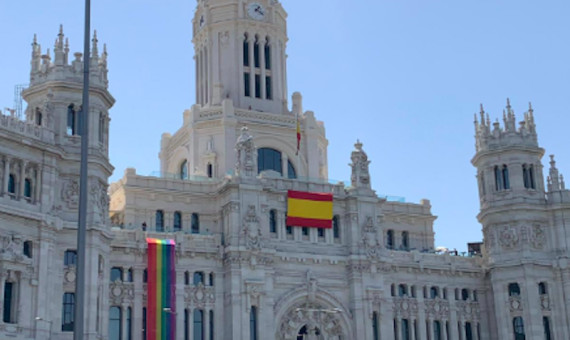 Fachada del Ayuntamiento de Madrid con la bandera de España y la LTGBI