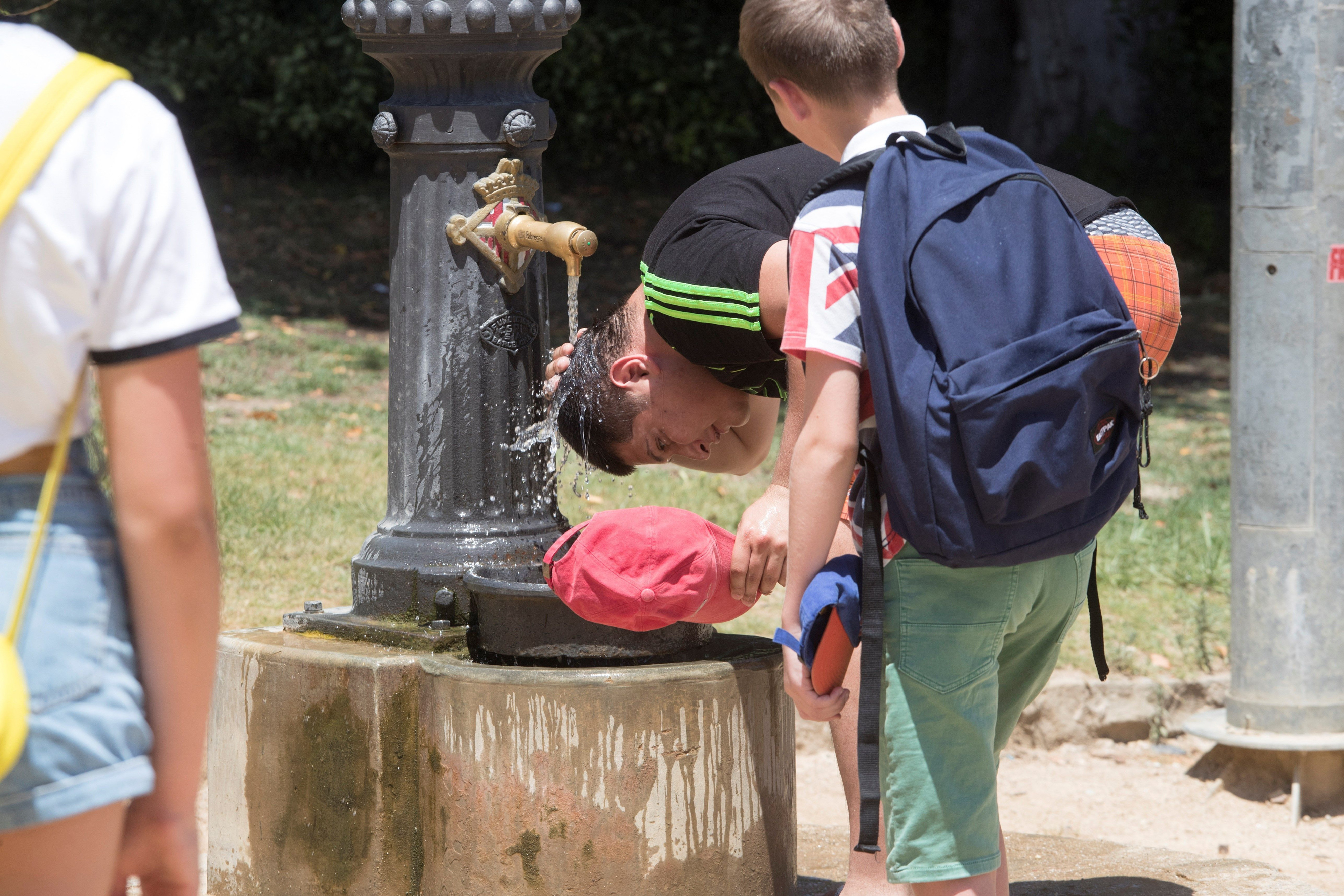 Un hombre mojándose la cabeza con agua en Barcelona durante la ola de calor / EFE-Marta Pérez